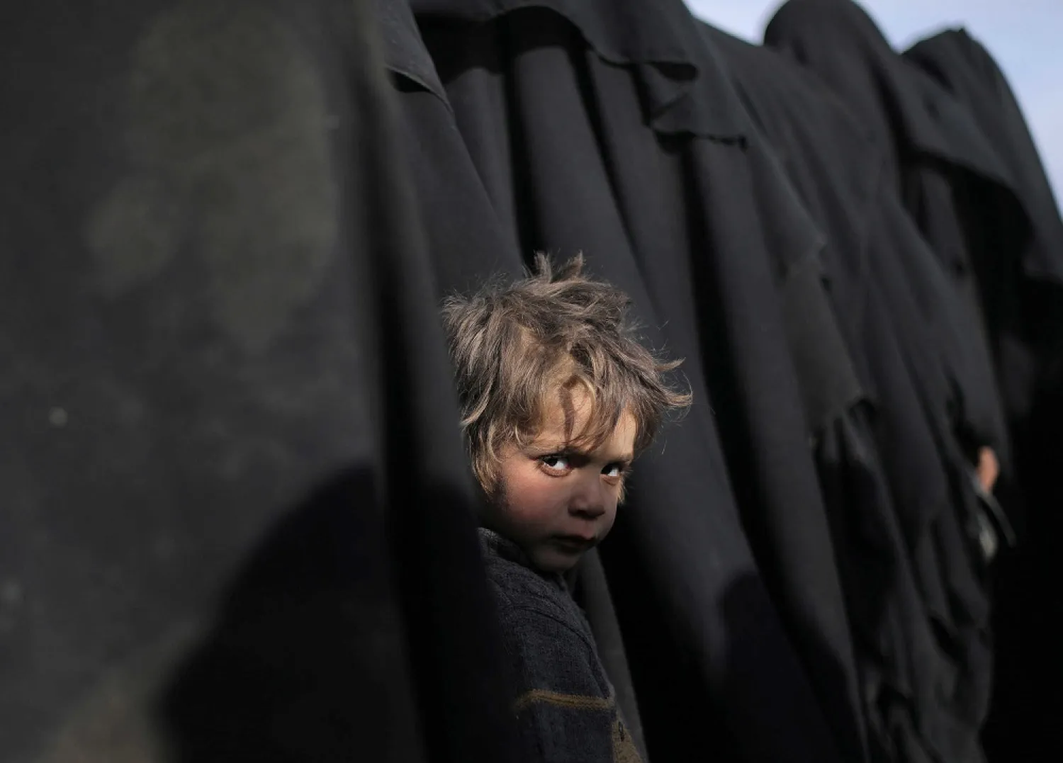 A boy looks at the camera near Baghouz, Deir Ezzor province, Syria, March 5, 2019. (Reuters)