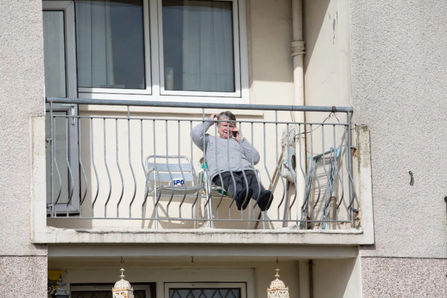 سيدة بريطانية تقضي وقتها في شرفة منزلها بعد فرض قيود على الحركة (إ.ب.أ)