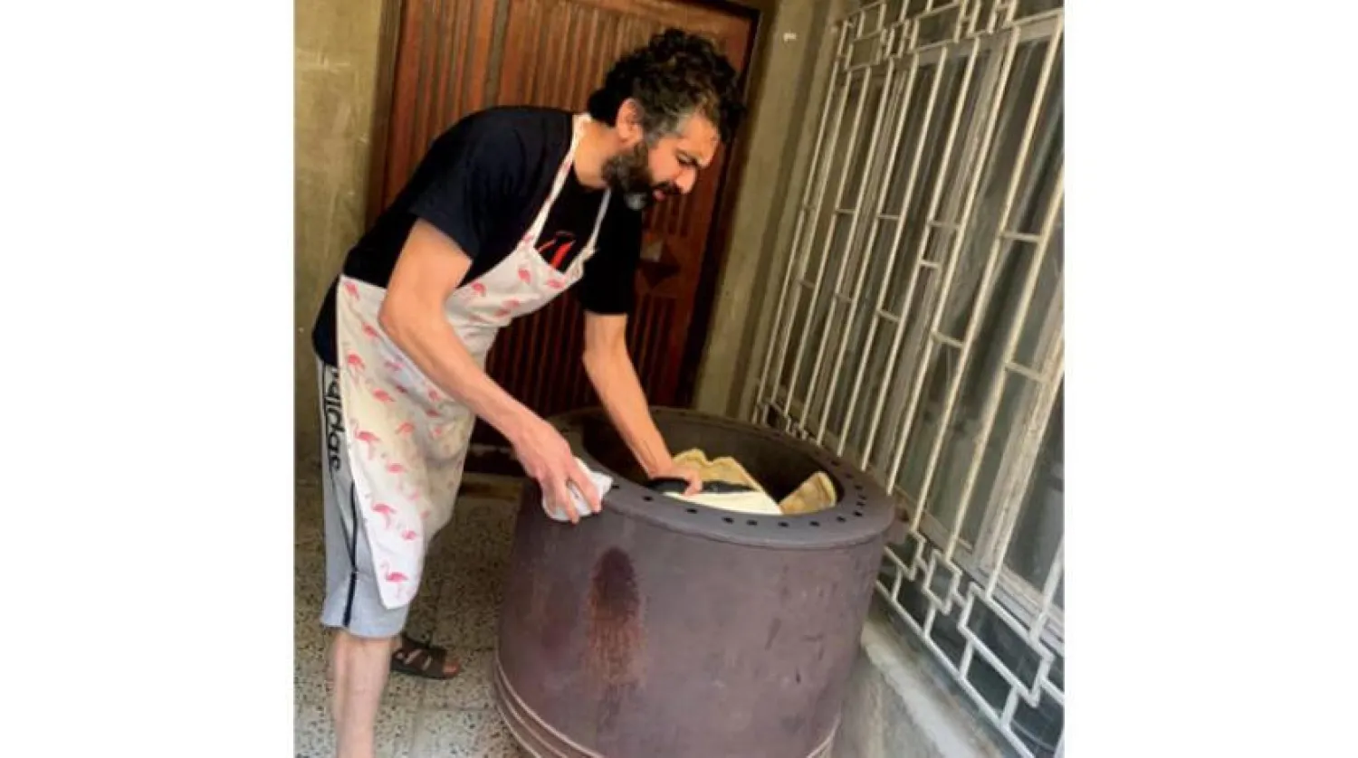 Philosophy professor Sattar Awwad makes local bread at his household residence in Baghdad, Iraq | Asharq Al-Awsat 