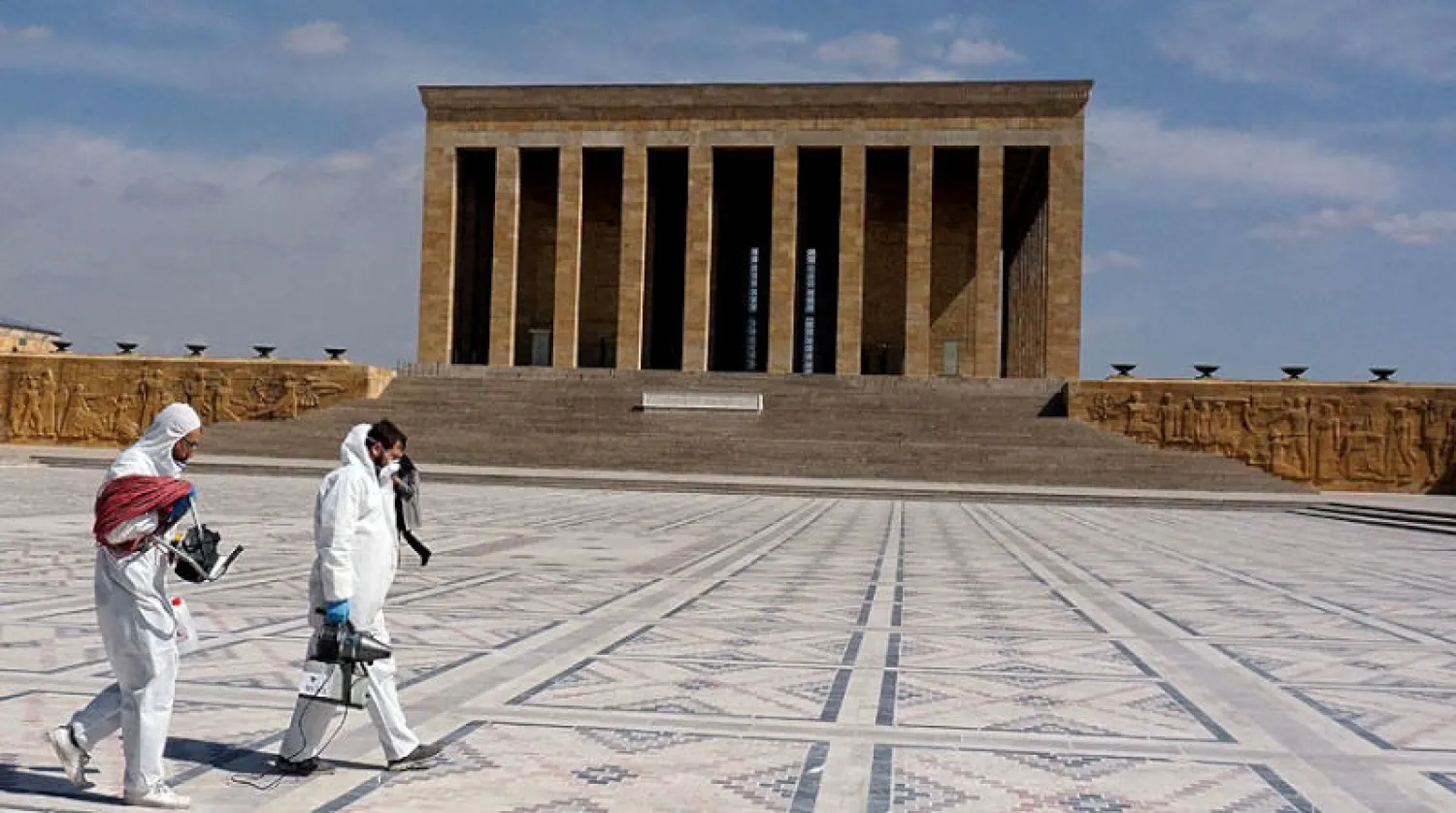 موظفان تركيان يعقمان ضريح مصطفى كمال أتاتورك أمس (أ.ف.ب)