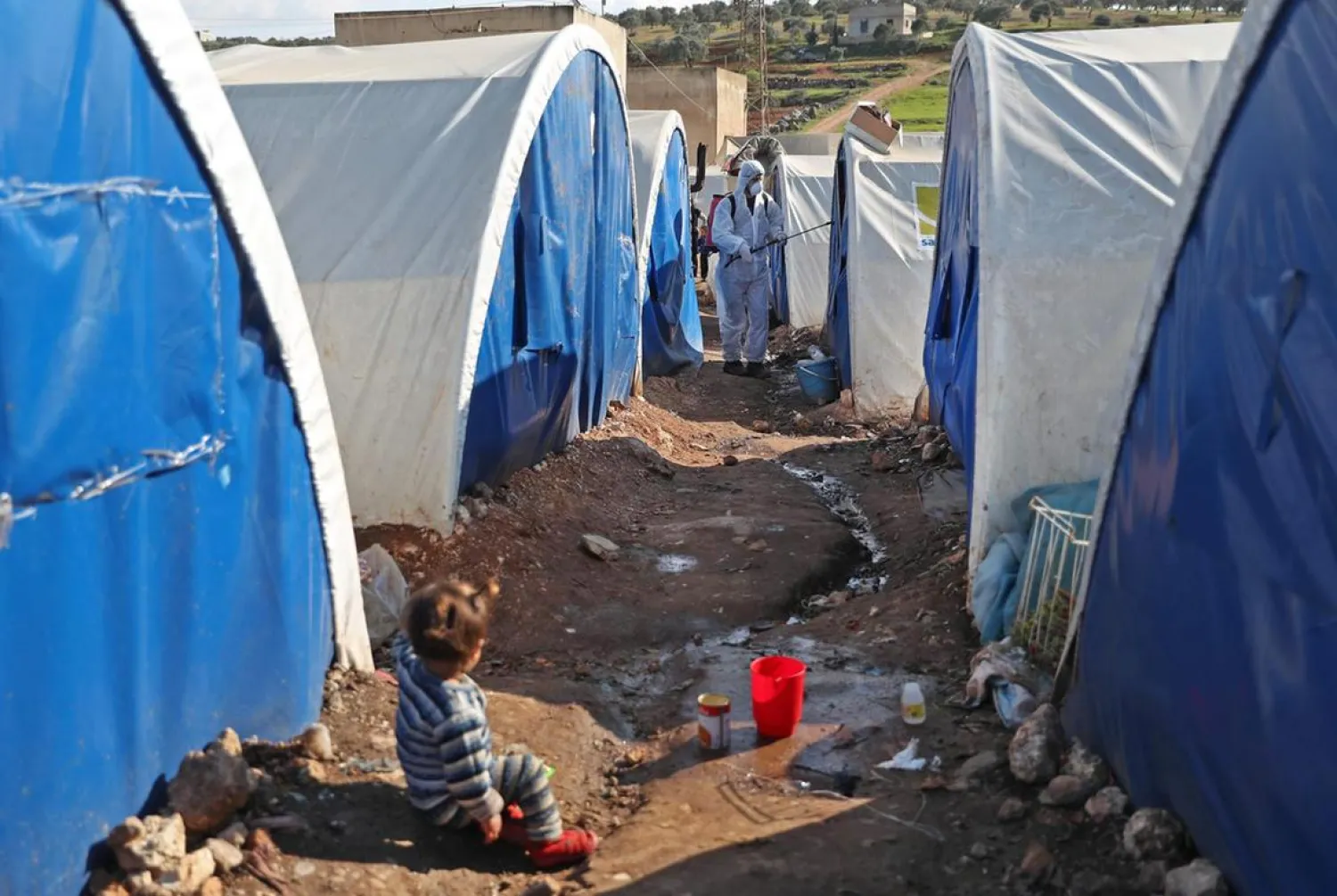 A member of the Syrian Violet NGO disinfects tents at a camp for displaced people in Kafr Jalis village, north of Idlib city. (AFP)