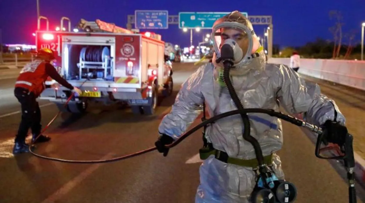 Tel Aviv yakınlarındaki tren istasyonunu sterilize etmeye hazırlanan bir itfaiyeci (AFP)