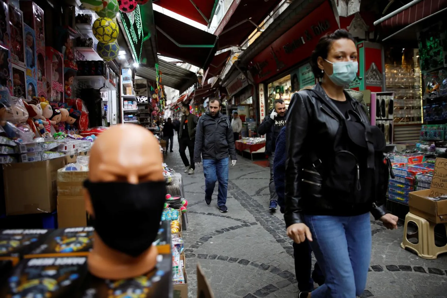 A woman wearing a protective face mask walks in a market at Eminonu neighbourhood during the outbreak of coronavirus disease (COVID-19), in Istanbul, Turkey, March 23, 2020. REUTERS/Umit Bektas
