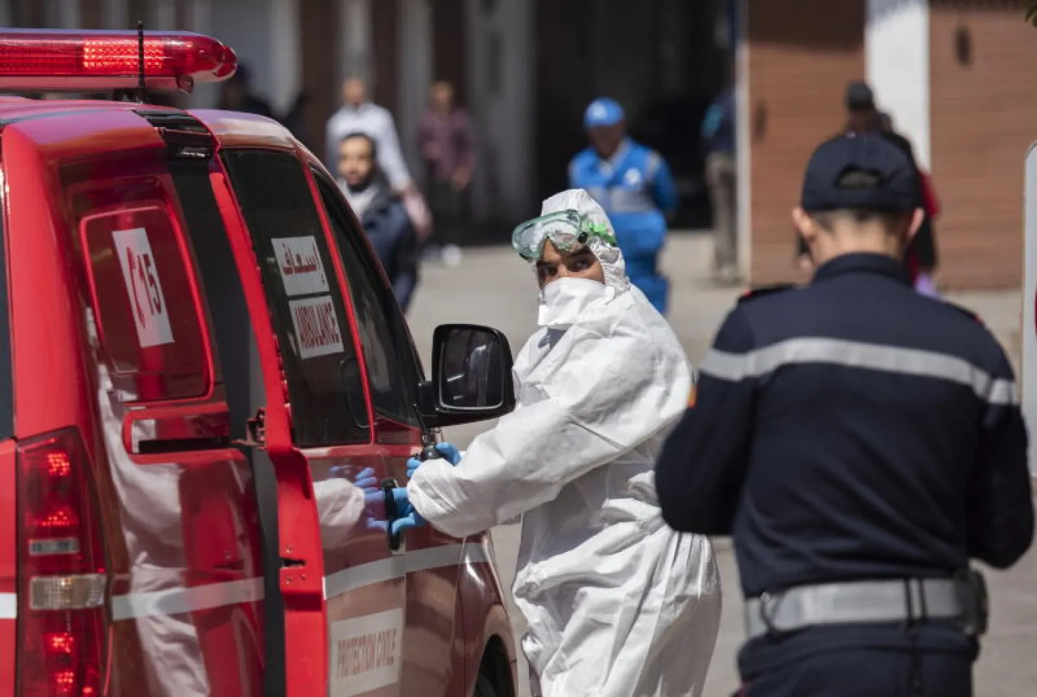 عنصر من فريق طبي خلال نقل شخص مشتبه بإصابته بكورونا في الرباط (إ.ب.أ)