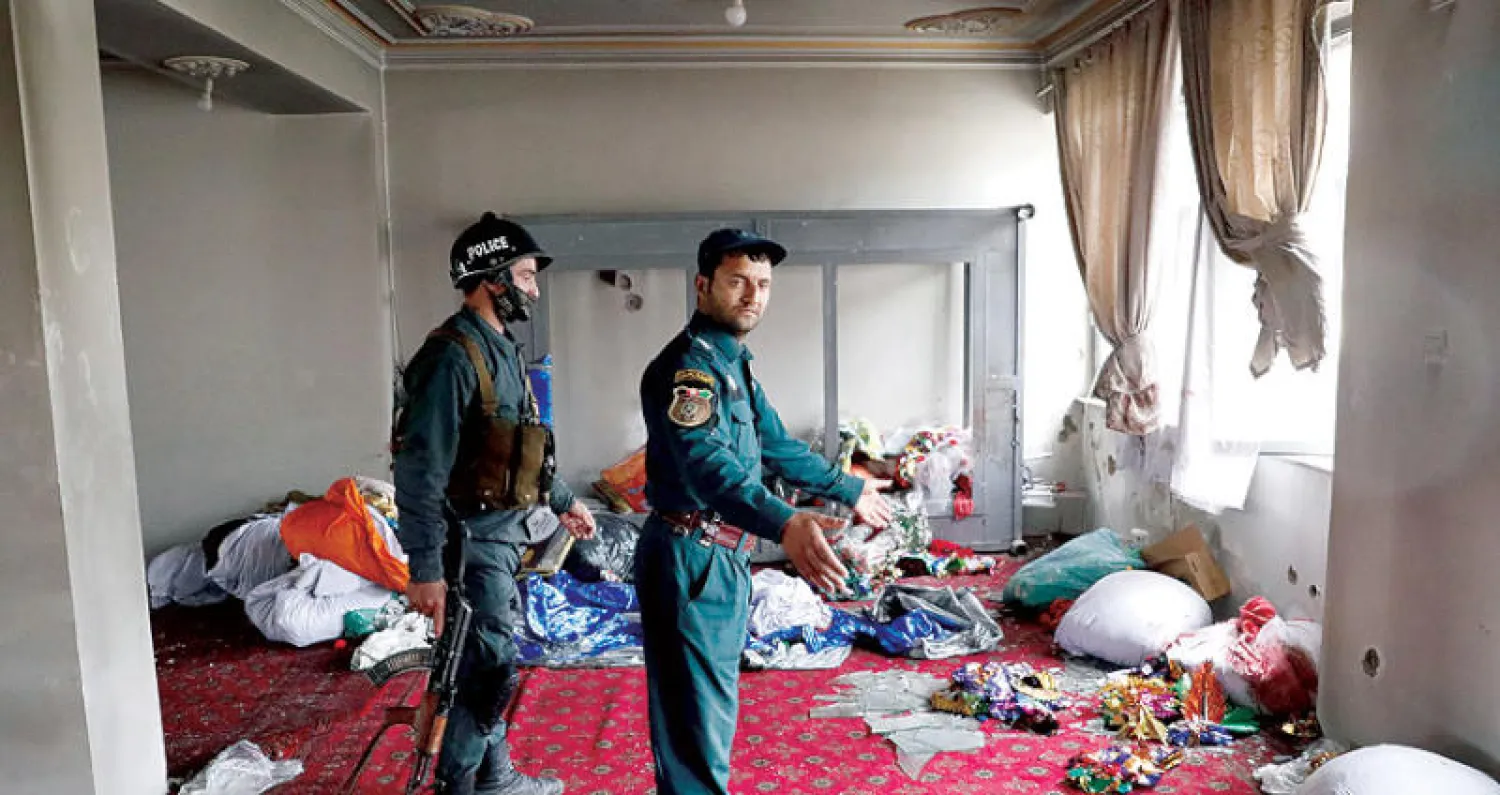 قوات أفغانية تتفحص موقع الهجوم في كابل أمس (رويترز)