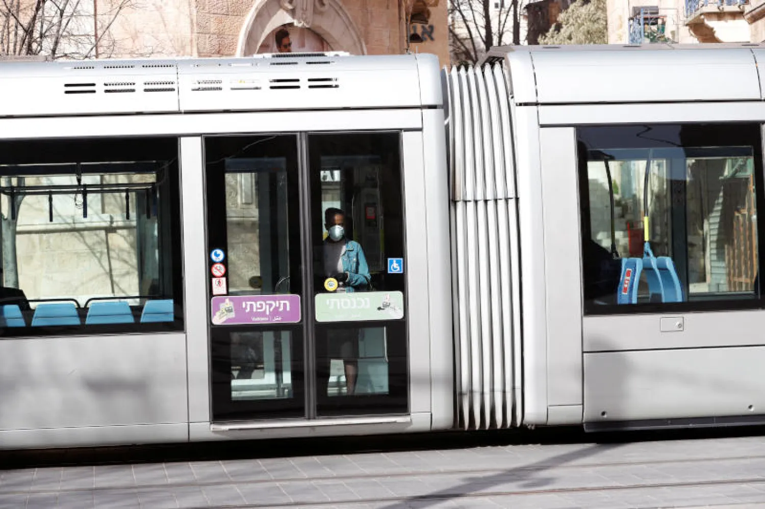 راكب يرتدي كمامة في قطار بإسرائيل (رويترز)