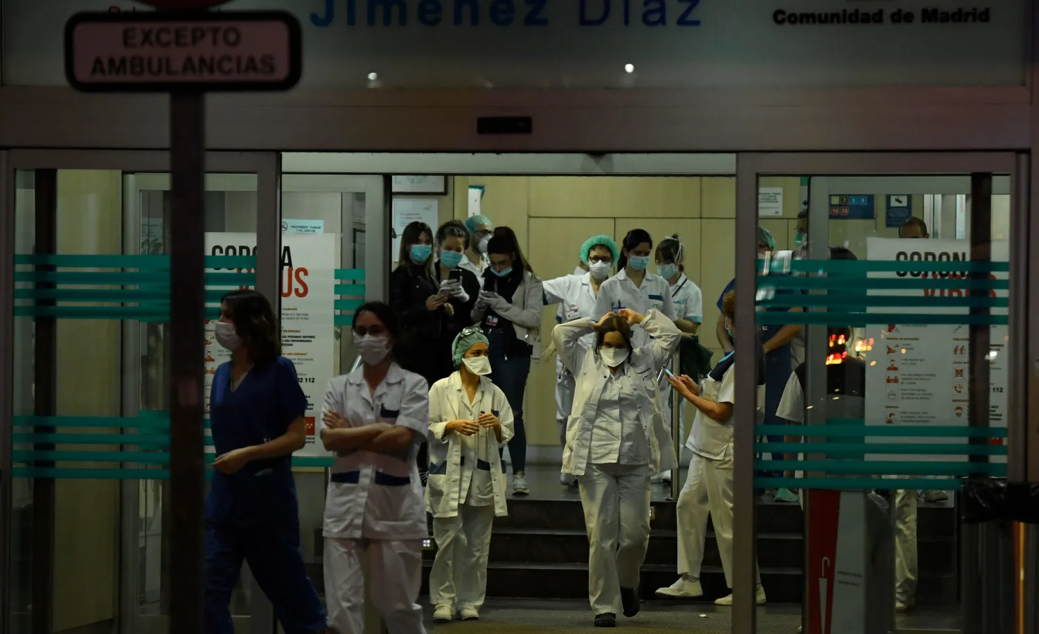 طواقم رعاية صحية يتعاملون مع أزمة كورونا في مدخل مستشفى مؤسسة خيمينيز دياز في مدريد (أ.ف.ب)