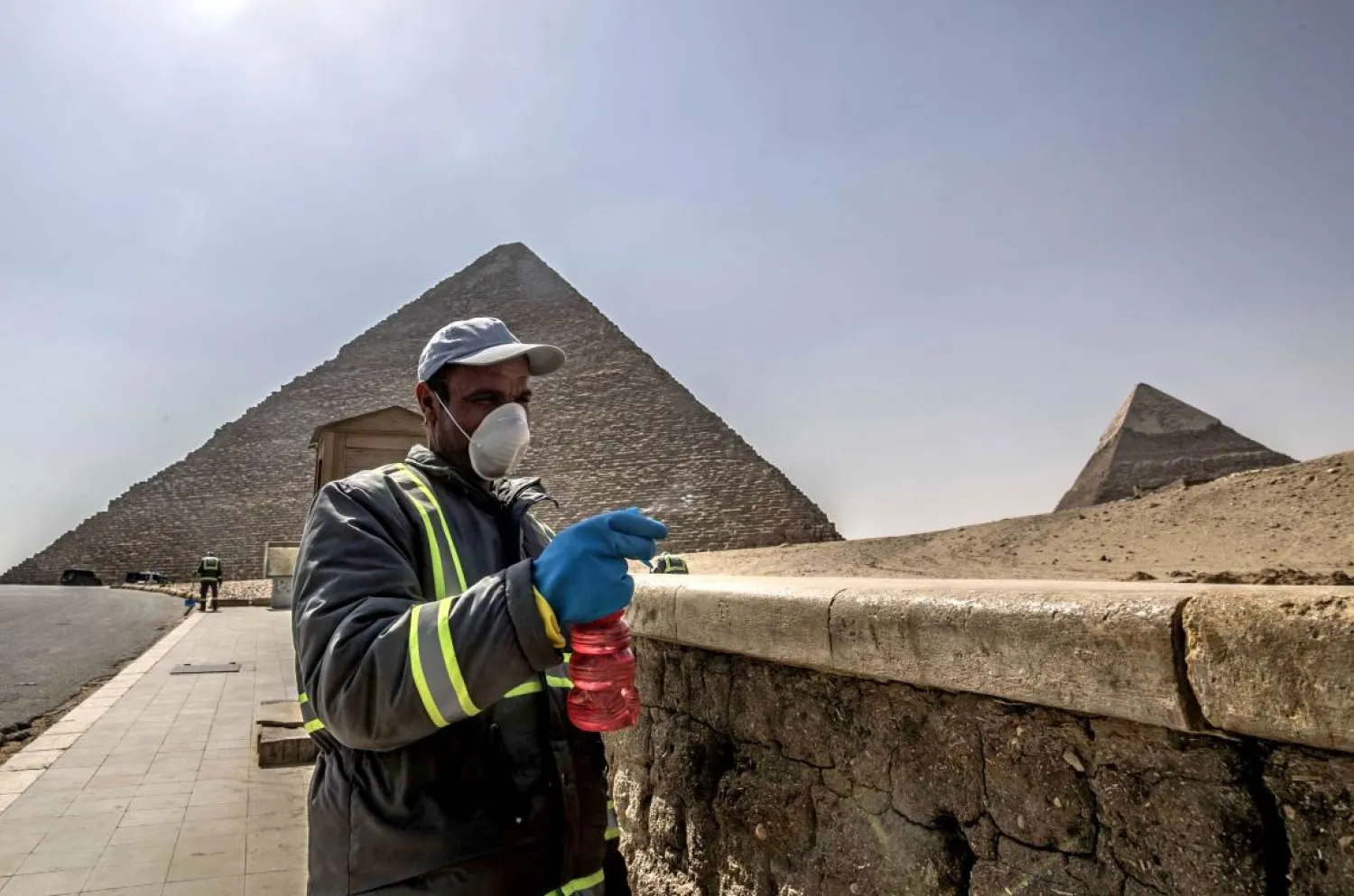 Egyptian municipality workers disinfect the Giza pyramids necropolis on the southwestern outskirts of the Egyptian capital Cairo on March 25, 2020. (AFP)
