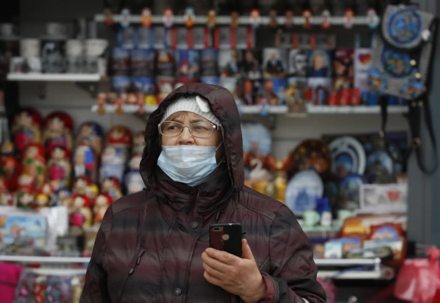 سيدة ترتدي قناعاً واقياً أثناء وجودها بأحد المتاجر في روسيا (إ.ب.أ)