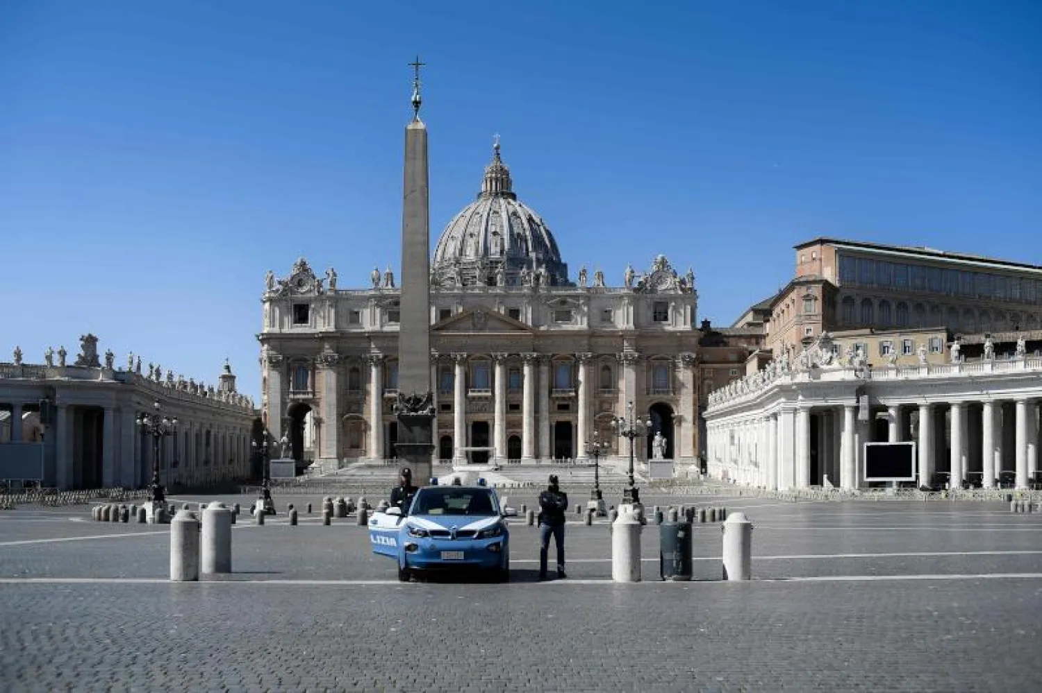 عنصران من الشرطة الإيطالية يقفان في ساحة القديس بيتر المغلقة وكنيستها في الفاتيكان (أ.ف.ب)
