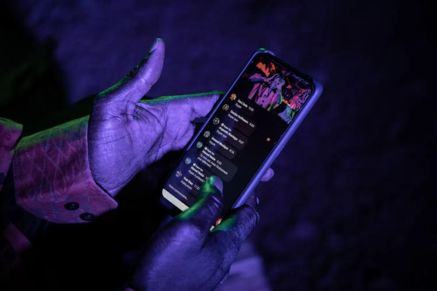 مستخدم يحمل هاتفه بينما يتابع نقلاً مباشراً على موقع فيسبوك (أ.ف.ب)