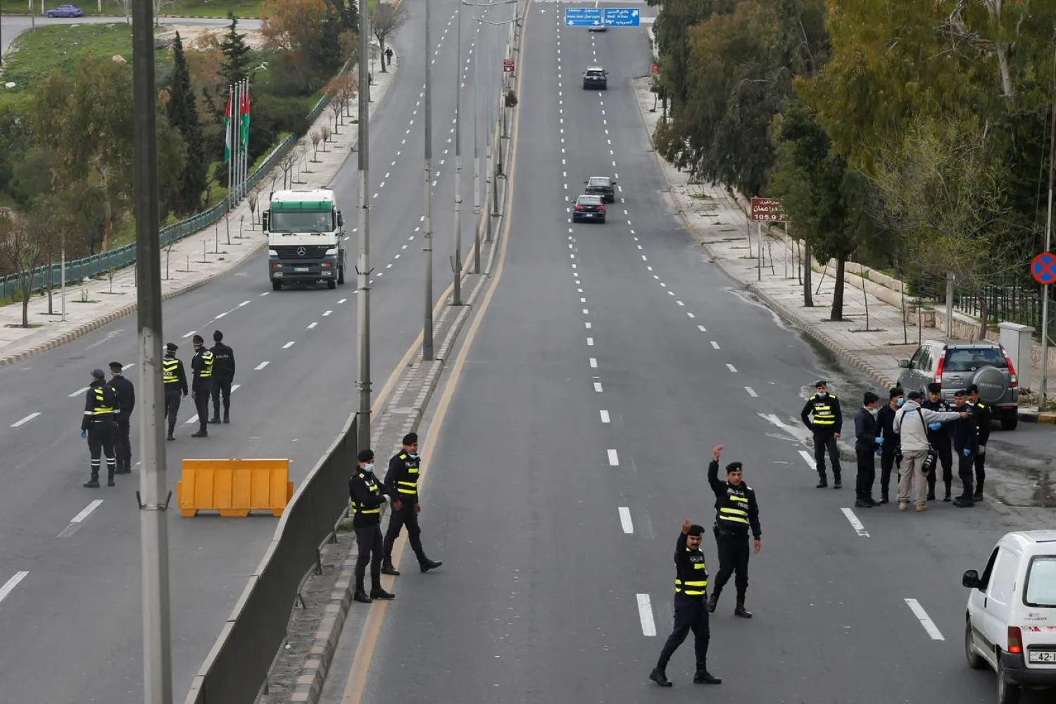 Jordanian police personnel guard at a checkpoint during the second day of a nationwide curfew, amid concerns over the coronavirus disease (COVID-19) spread, in Amman, Jordan March 22, 2020. REUTERS/Muhammad Hamed