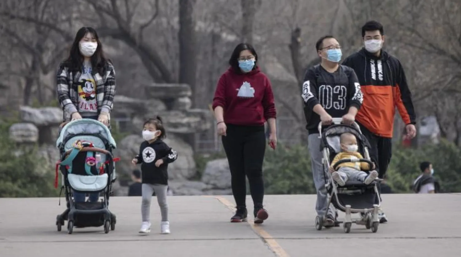Pekin’deki Çinli bir aile maske takarken (EPA)
