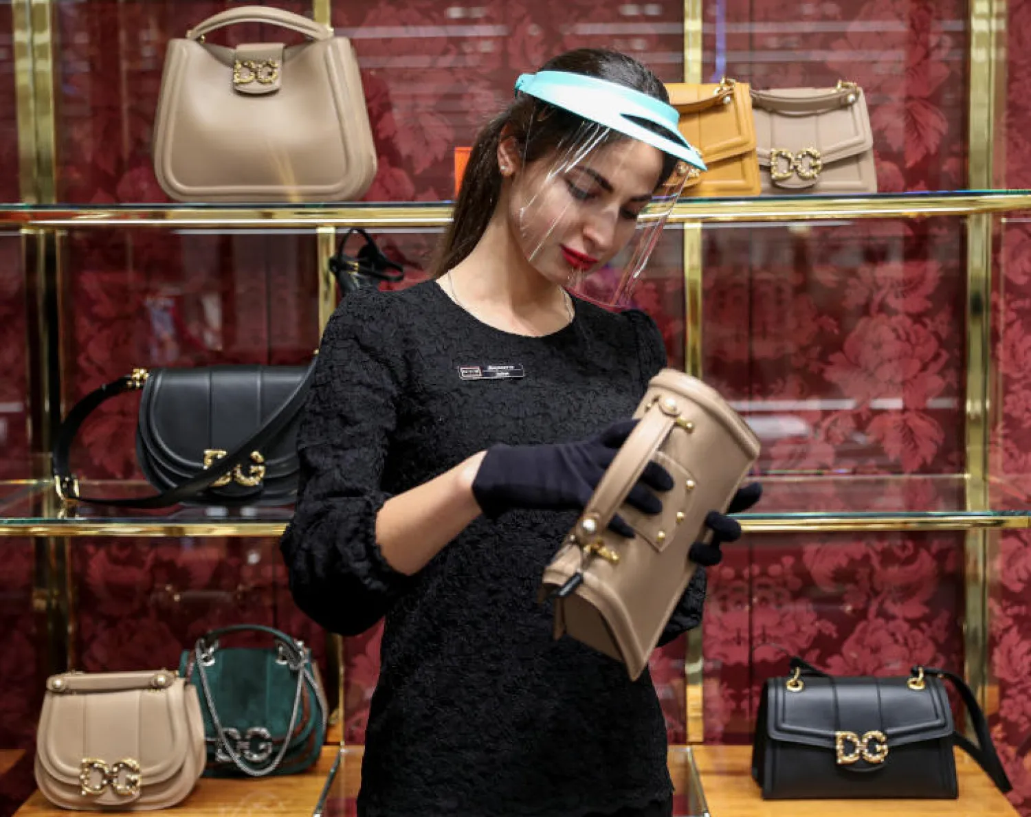 عاملة في متجر للحقائب في موسكو تضع قناعاً واقياً (رويترز)