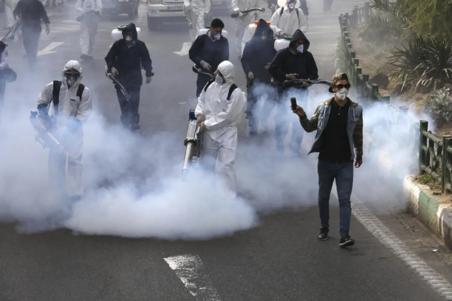 رجال إطفاء يعقمون الشوارع ضمن تدابير الحد من انتشار «كورونا» في طهران (أ.ب)