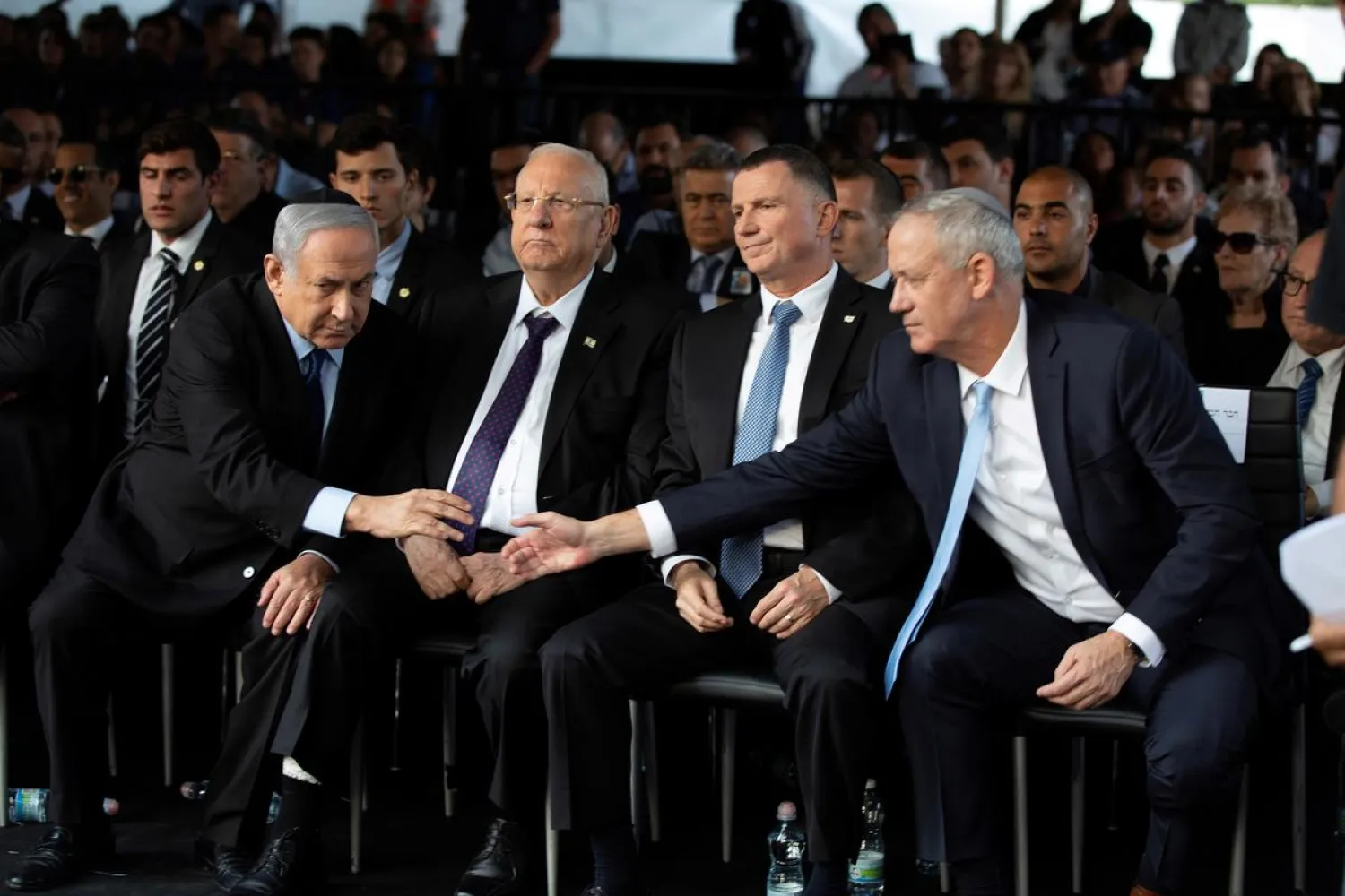 Head of Israel's Blue and White Party Benny Gantz and Israeli Prime Minister Benjamin Netanyahu shake hands as they attend a memorial ceremony in Jerusalem , November 10, 2019. (Reuters)