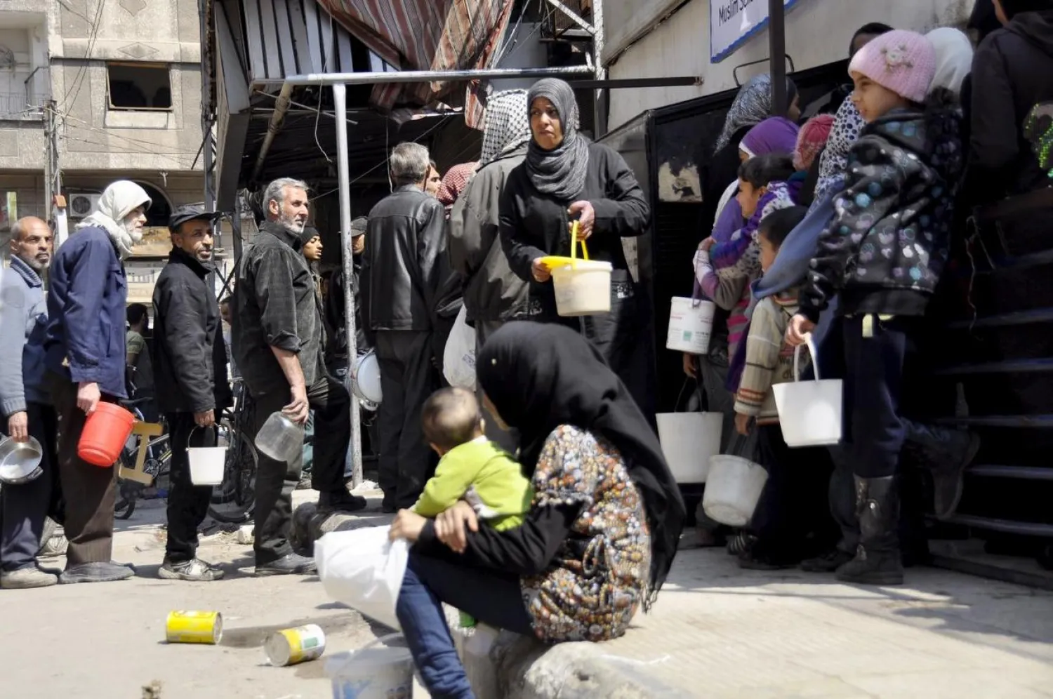 Residents wait in line to receive food aid in Yarmouk camp (File photo: Reuters)
