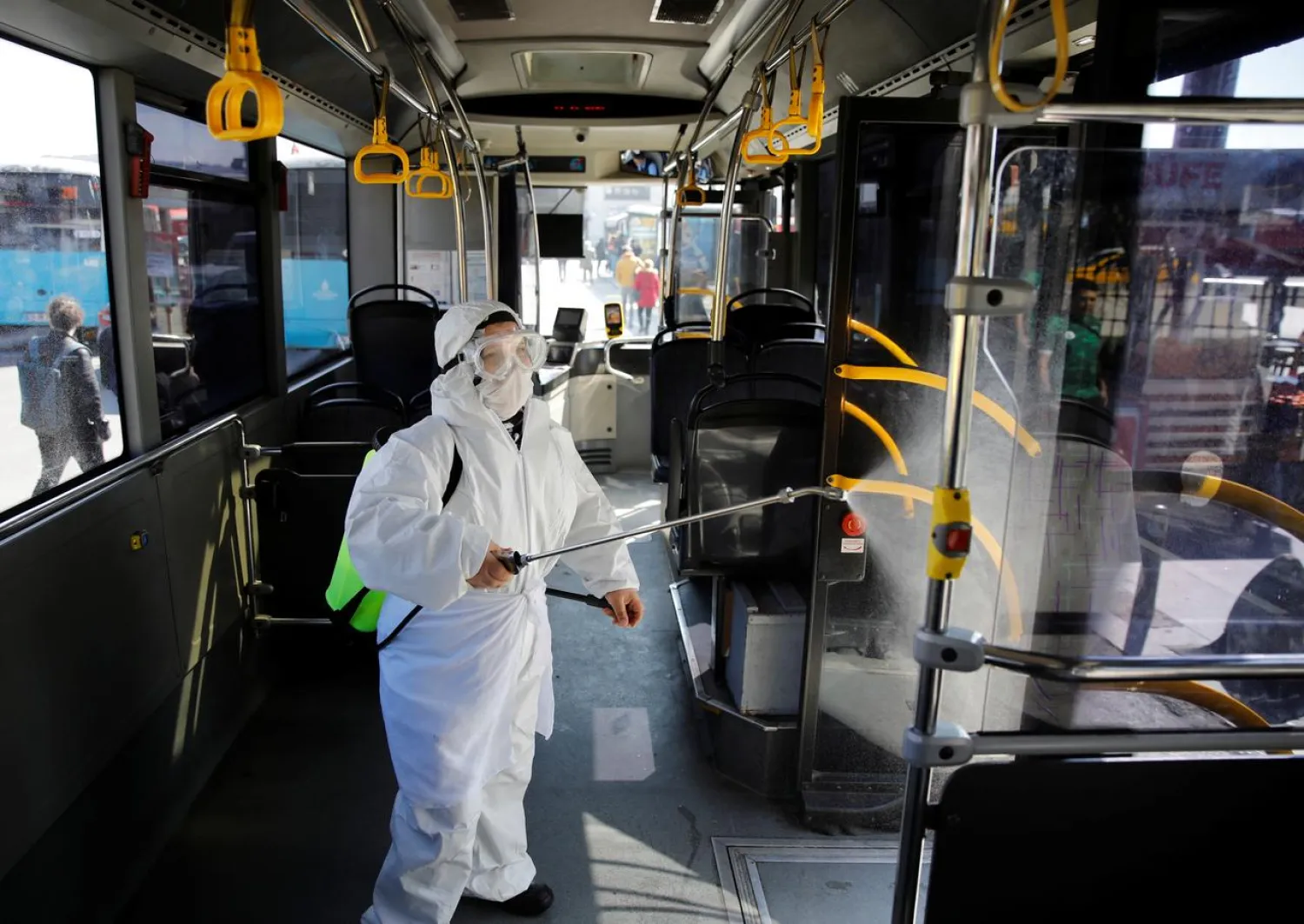 A worker in a protective suit disinfects a bus due to coronavirus concerns in Istanbul, Turkey March 11, 2020. REUTERS/Umit Bektas