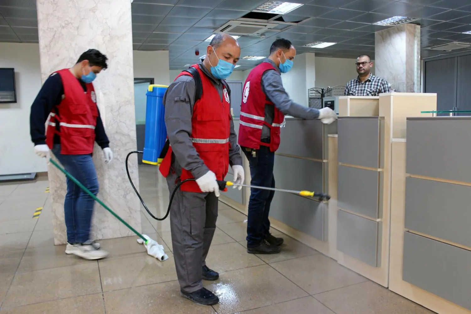 FILE PHOTO: Members of Red Crescent spray disinfectants, as part of precautionary measures against coronavirus disease (COVID-19) at government offices in Misrata, Libya, March 21, 2020. REUTERS/Ayman Al-Sahili/File Photo
