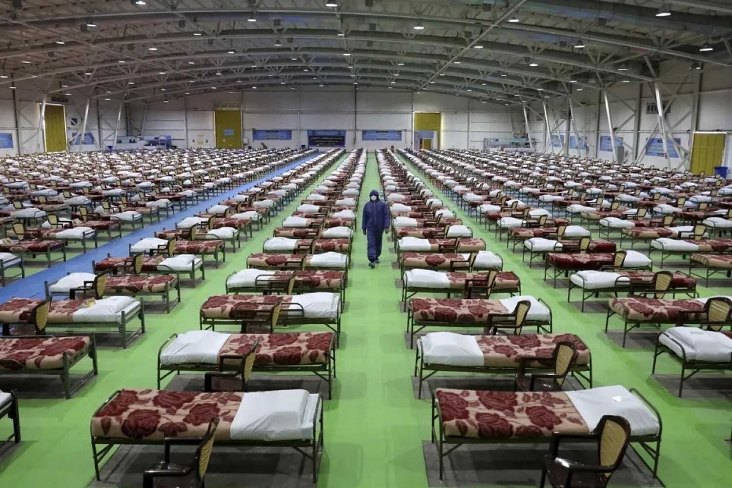 A member of the Iranian army walks past beds at a temporary hospital for COVID-19 patients set up by the army at the international exhibition center in Tehran, Iran, March 26, 2020. (AP)