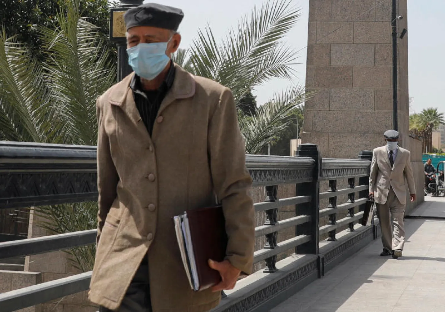 كبار السن يرتدون كمامات أعلى كوبري قصر النيل في العاصمة المصرية القاهرة (رويترز)