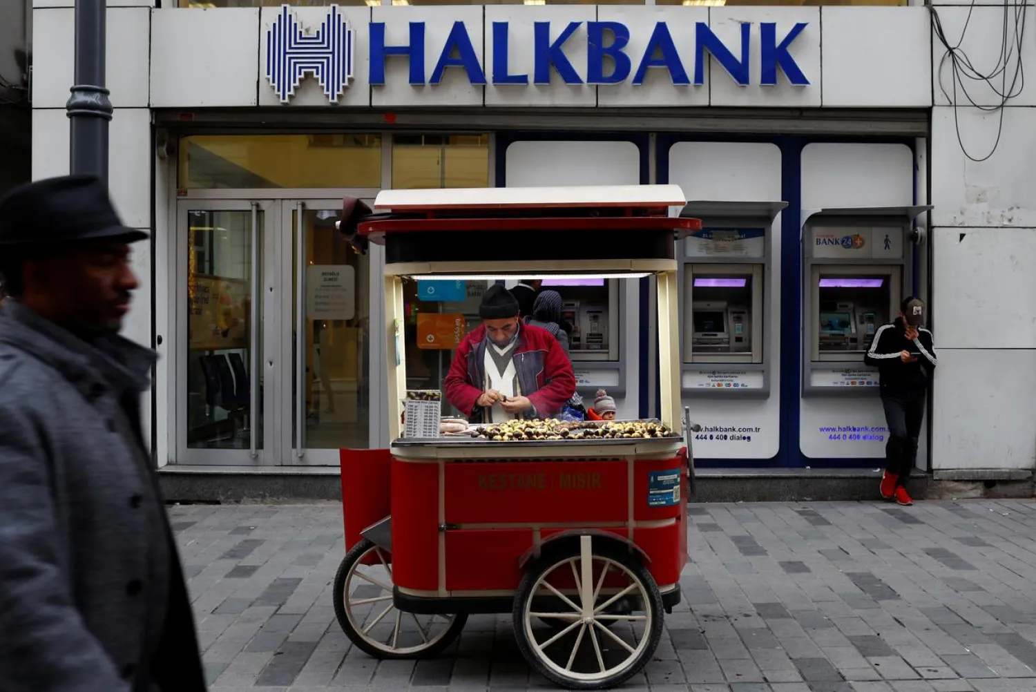 A street vendor sells roasted chestnuts in front of a branch of Halkbank in central Istanbul, Turkey, January 10, 2018. (Reuters)