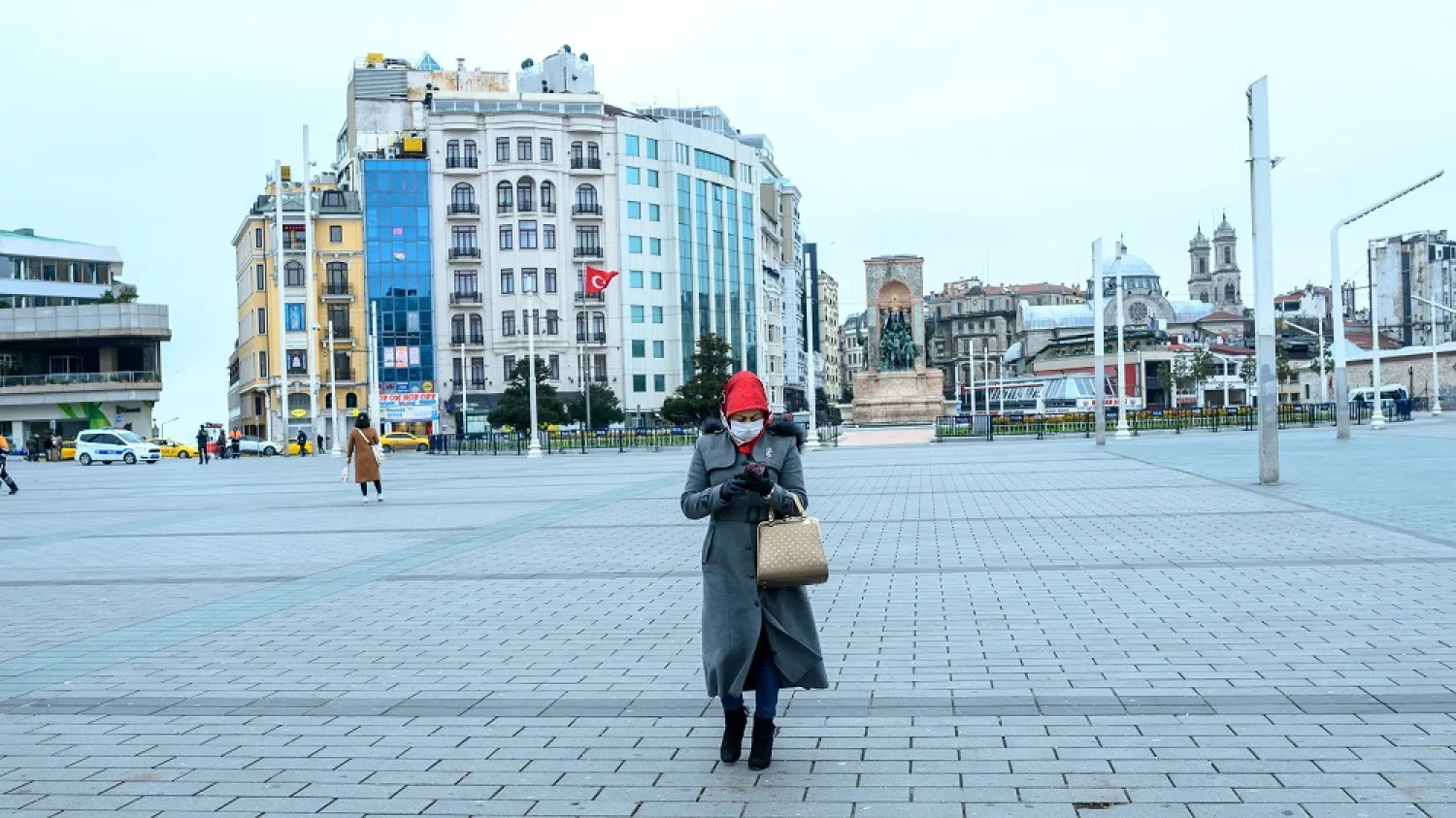 A woman walks across the iconic Taksim Square, deserted due to the coronavirus outbreak, Istanbul, Turkey, March 26, 2020. (Getty Images)
