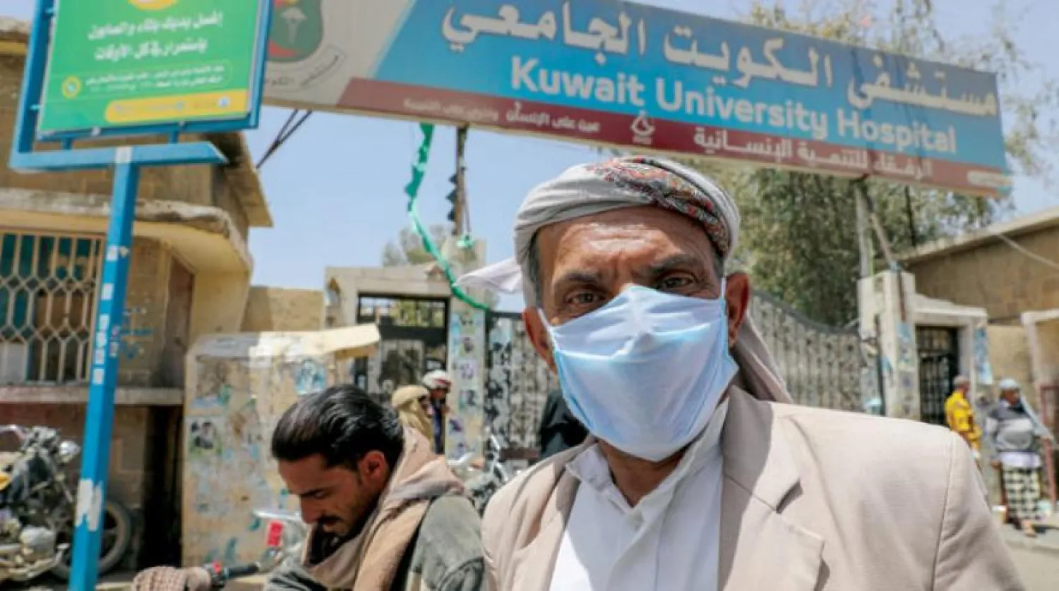 Husi milisler tarafından hedef alınan Kuveyt Üniversitesi Hastanesi önünde maskesi ile bekleyen bir Yemenli. (Reuters)