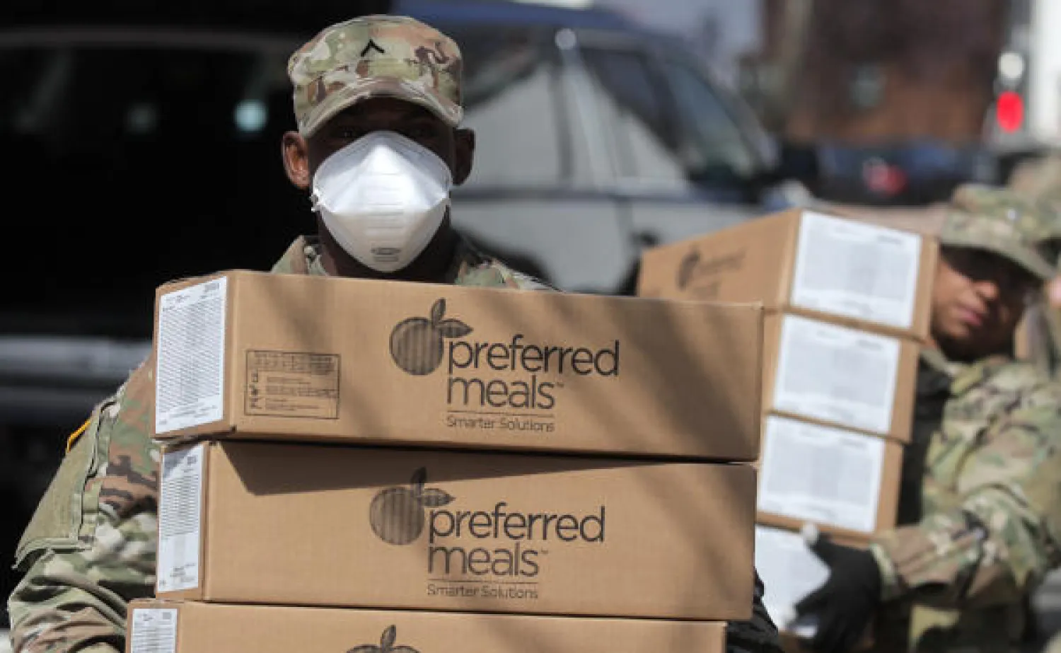 عناصر من الحرس الوطني الأميركي تنقل وجبات لتوزيعها مجاناً على السكان في مانهاتن مع تفشي وباء كورونا (رويترز)
