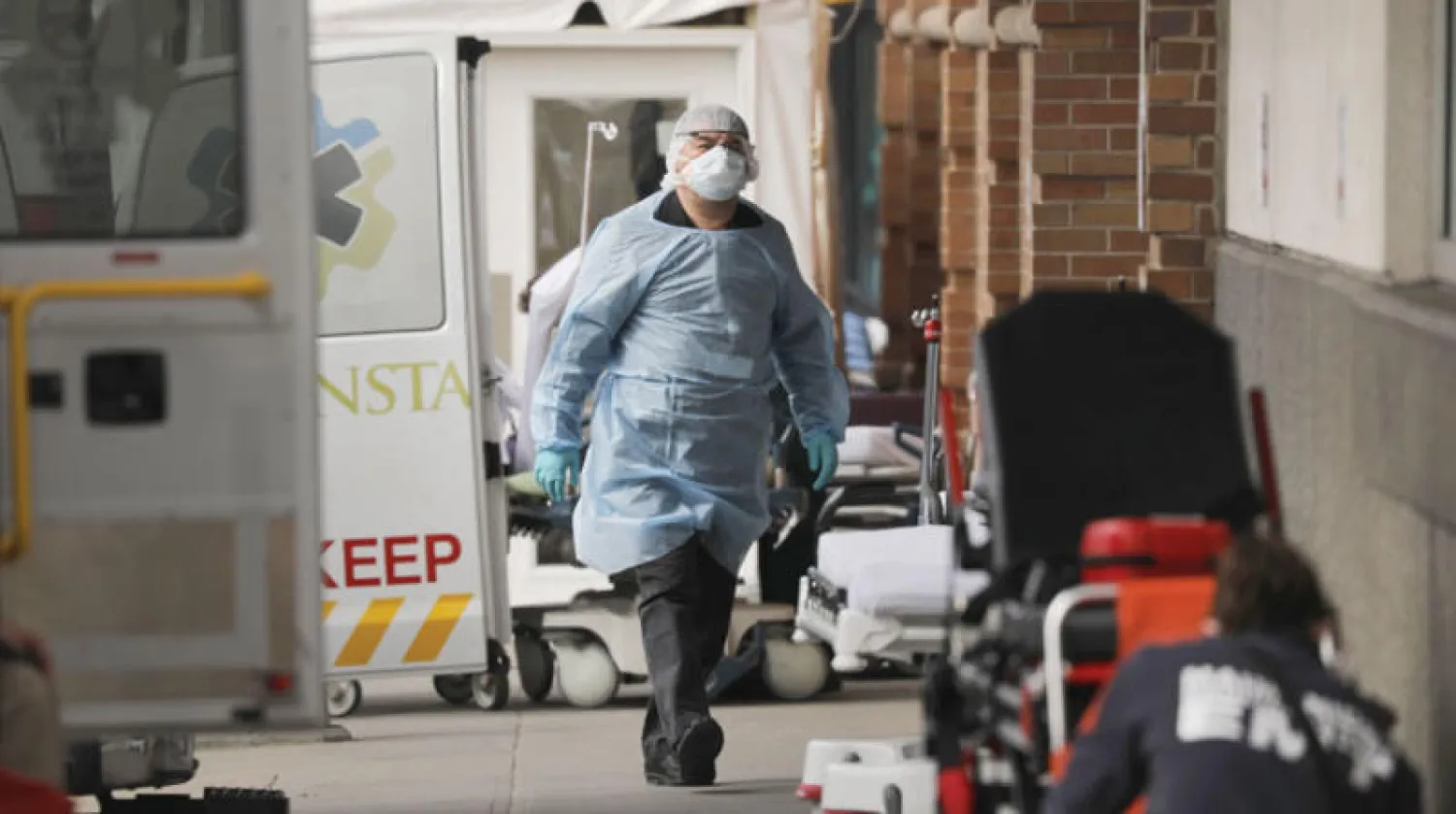 طبيب يستعد لفحص مصاب جديد في نيويورك أمس (أ.ف.ب)