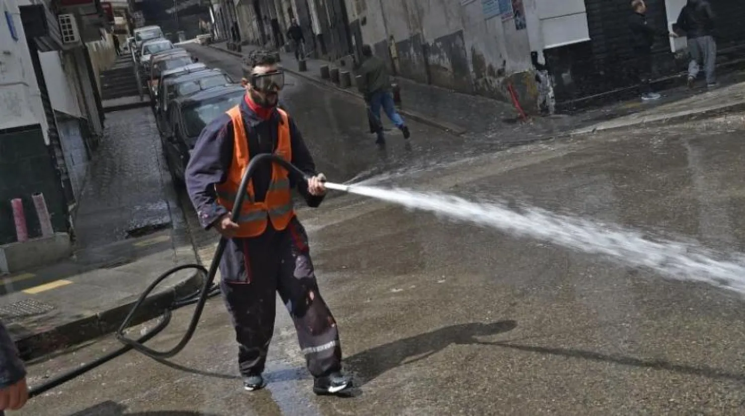 Başkent Cezayir’deki bir cadde dezenfekte ediliyor (AFP)
