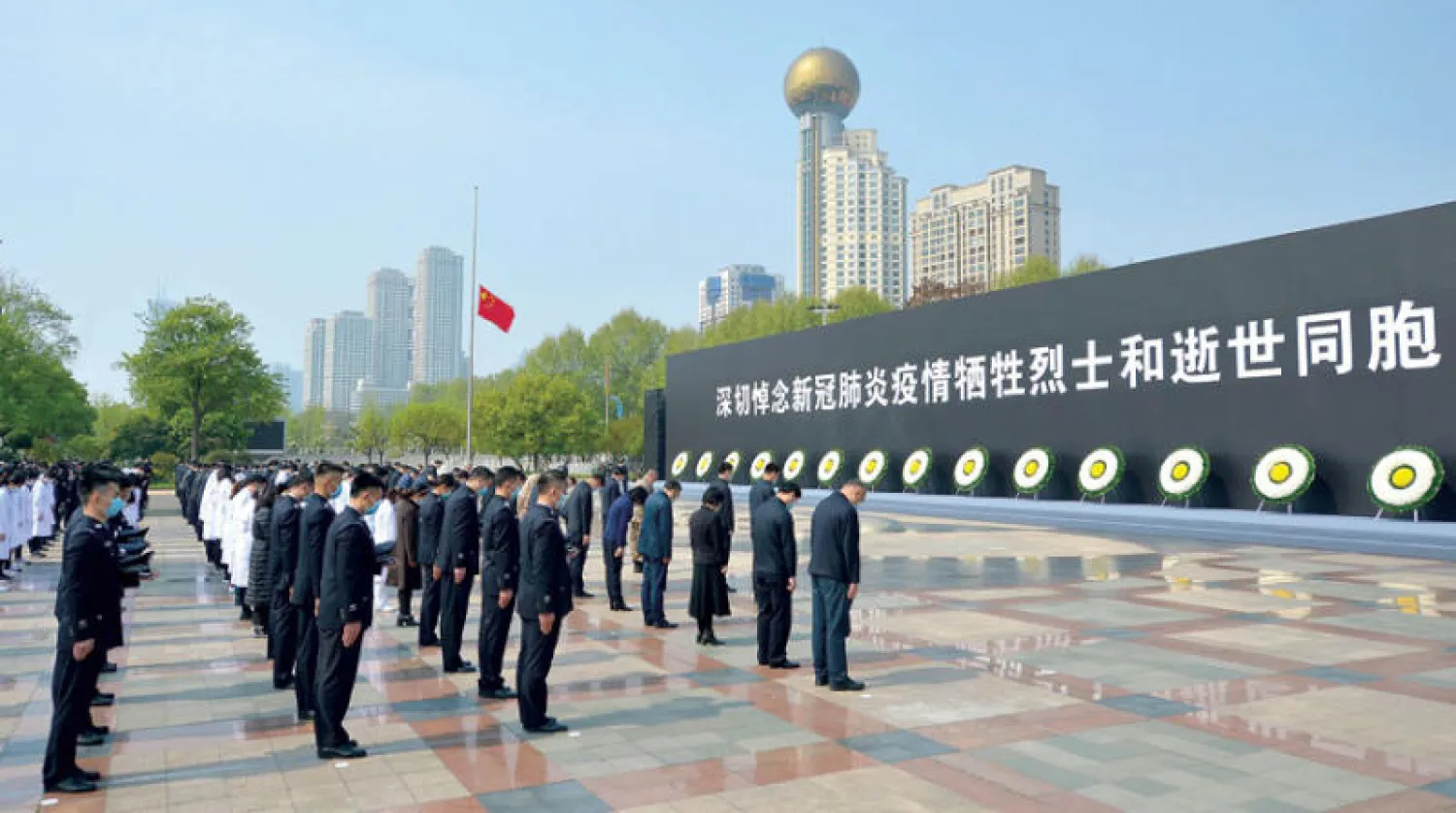 رجال أمن وأطباء يشاركون في تكريم ضحايا «كوفيد-19» في ووهان أمس (أ.ف.ب)