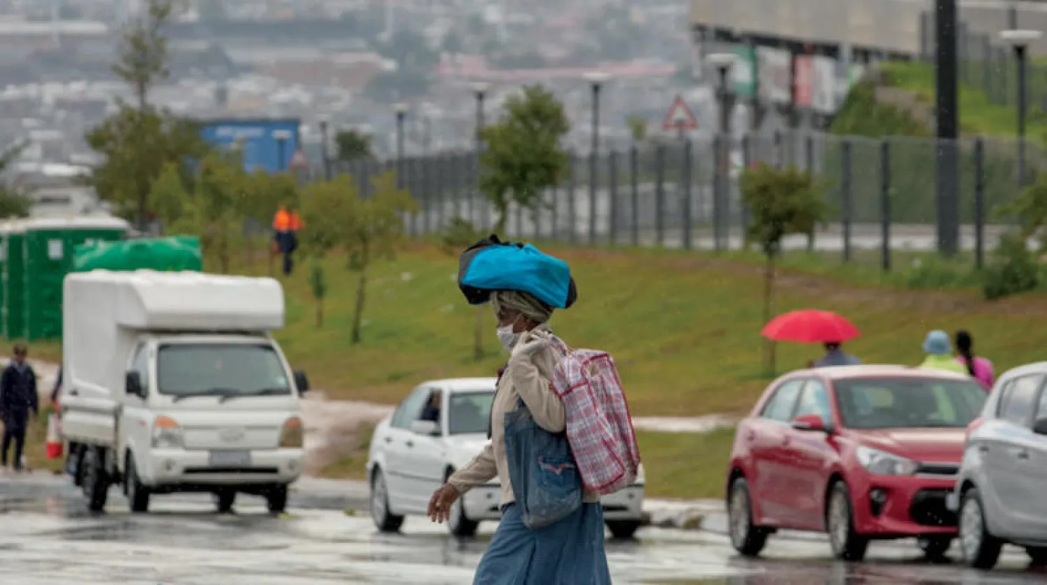 سيدة ترتدي قناعاً واقياً وتحمل أكياس تسوّق في جوهانسبورغ أمس (أ.ب)