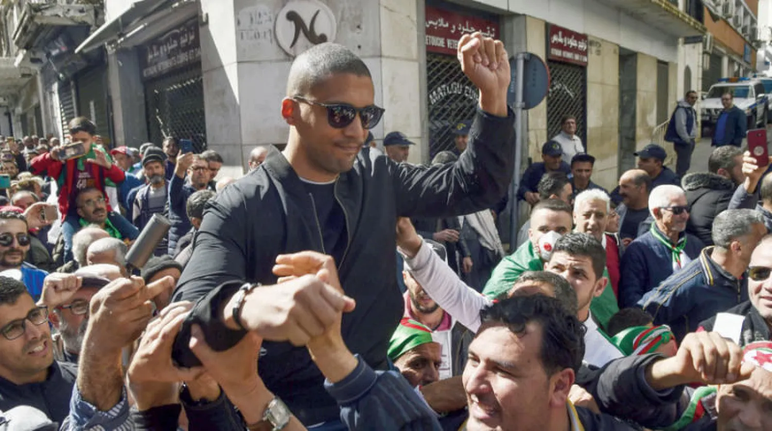 جزائريون يحملون على ظهورهم الصحافي خالد درارني خلال مظاهرة  للتنديد بتضييق السلطات على وسائل الإعلام (أ.ف.ب)