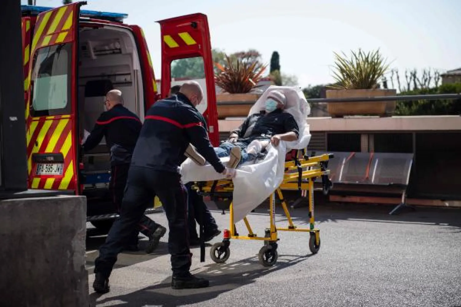 رجال إطفاء ينقلون  مريضاً مصاباً بفيروس كورونا في جنوب فرنسا (أ.ف.ب)