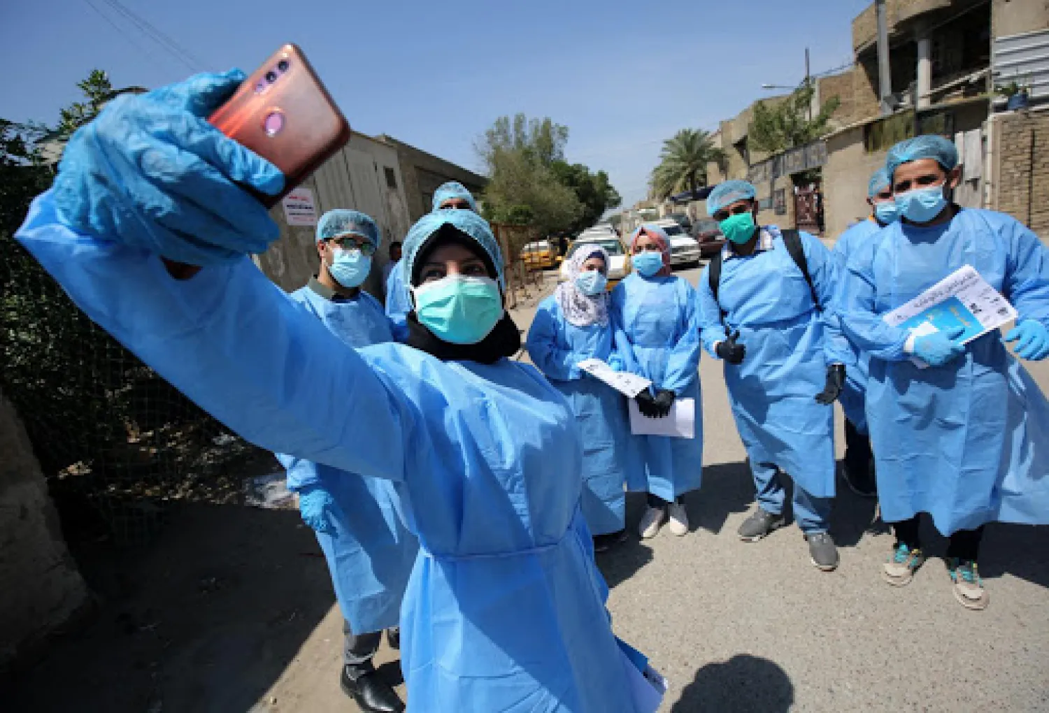 Doctors pose for a selfie before testing residents for Covid-19 in the capital Baghdad's suburb of Sadr City. AFP file photo