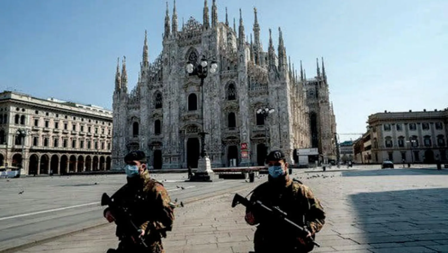 جنديان يرتديان كمامات في الميدان الرئيسي بمدينة ميلانو أول من أمس (نيويورك تايمز)