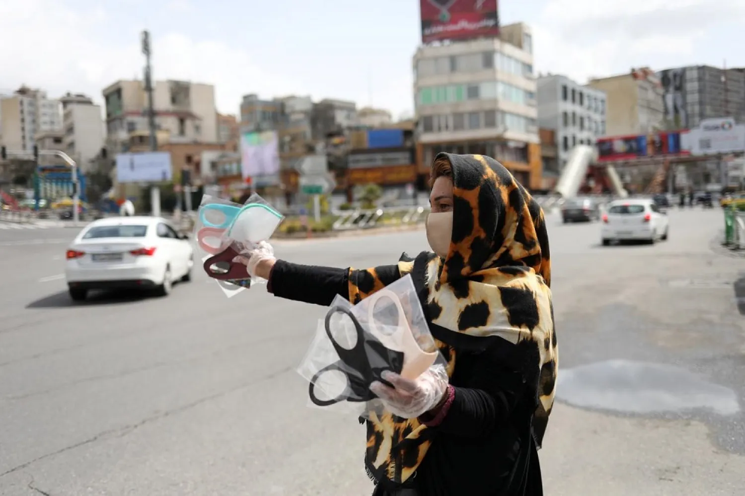 A woman wears a protective face mask and gloves, amid fear of the coronavirus, as she sells the masks in Tajrish square in Tehran, Iran April 2, 2020. (Reuters)
