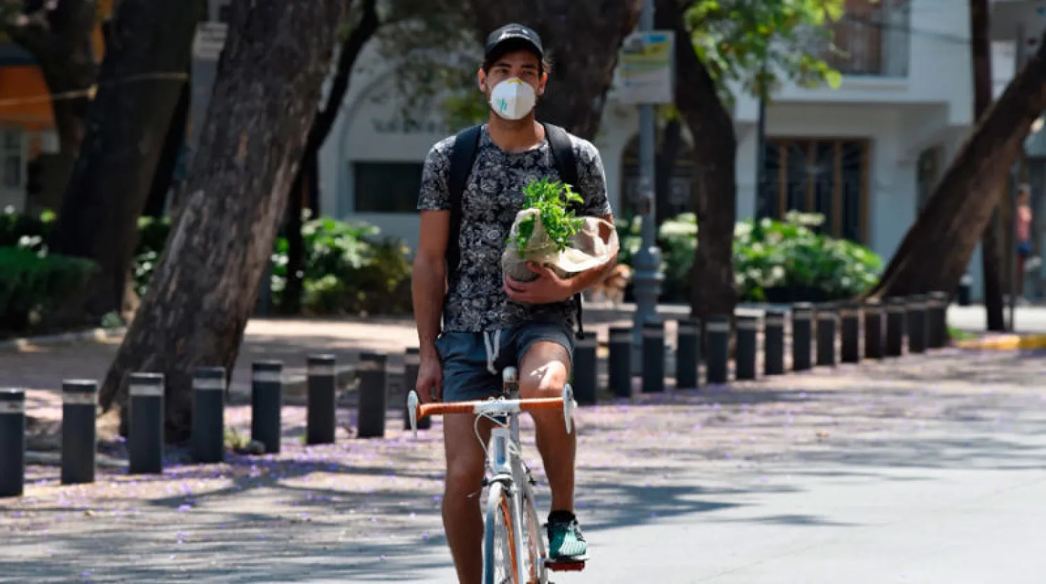 رجل يرتدي كمامة على دراجته (أ.ف.ب)