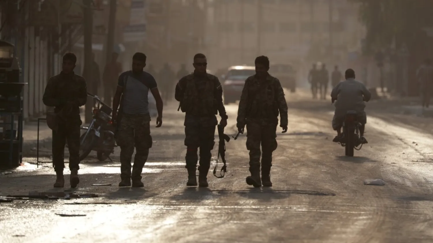 Turkey-backed Syrian fighters walk together in the border town of Tal Abyad. Khalil Ashawi/Reuters