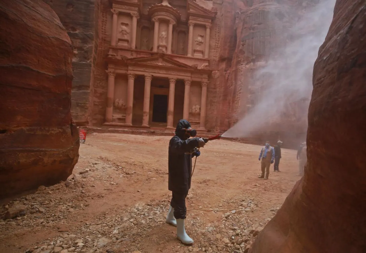 A laborer sprays disinfectant in Jordan's archaeological city of Petra south of the capital Amman on March 17, 2020, to prevent the spread of COVID-19. ( AFP)