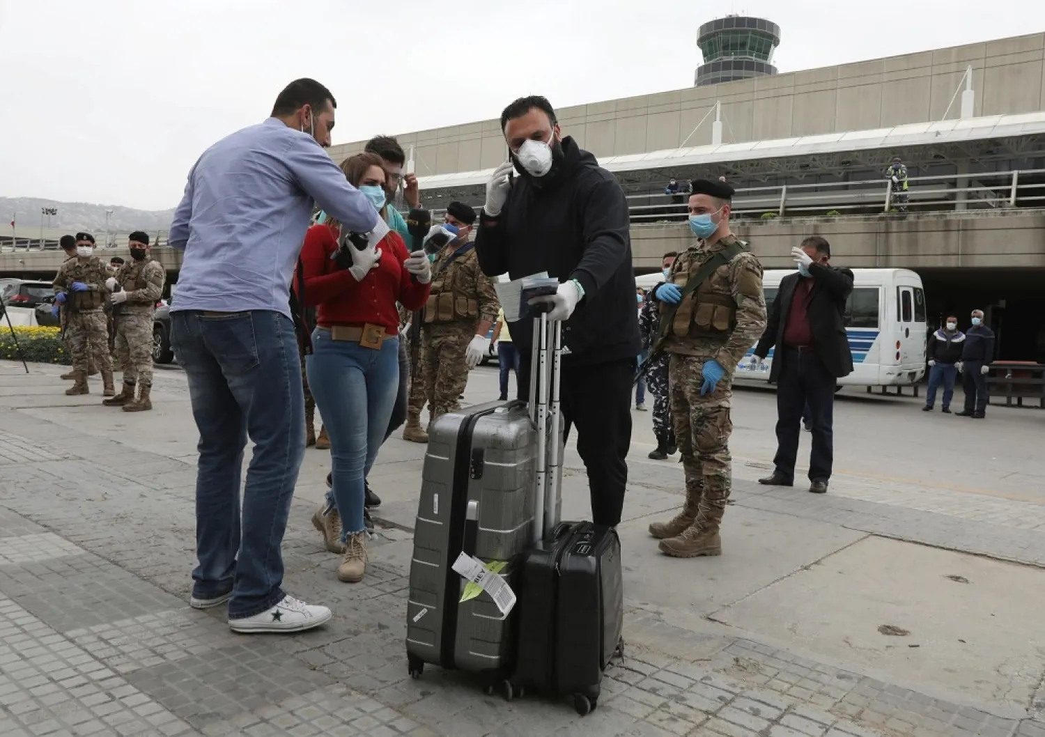 A Lebanese, who was stranded abroad by coronavirus lockdowns, is pictured wearing a face mask as he holds his luggage upon his arrival at Beirut’s international airport, Lebanon April 5, 2020. (Reuters)