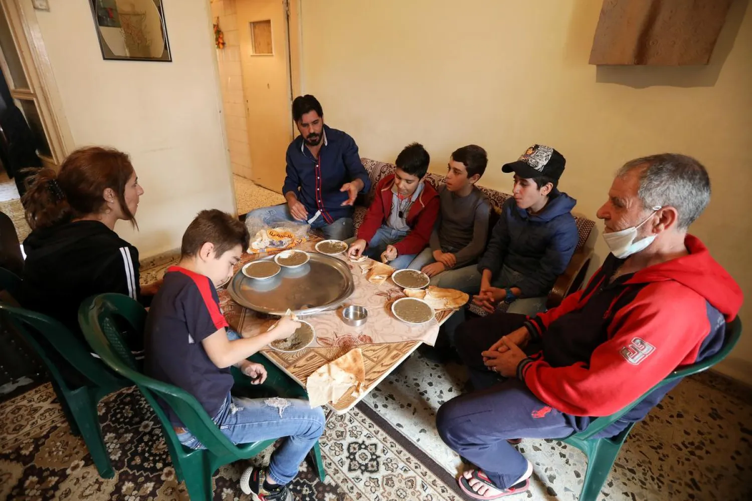 Hassan Zeitar, 39, eats with his family inside his home during a countrywide lockdown to combat the spread of coronavirus, in Choueifat, Lebanon March 30, 2020. (Reuters)