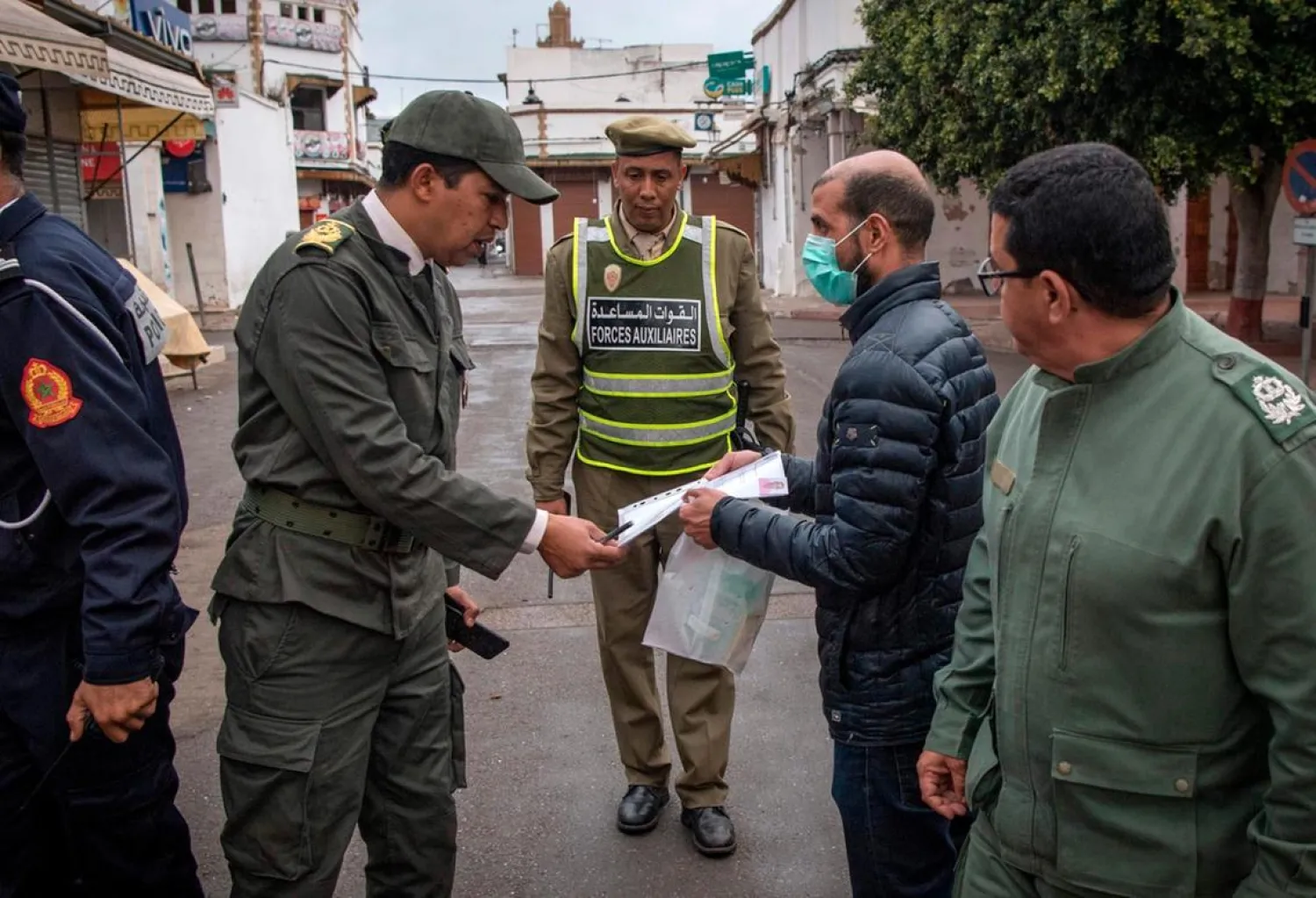 Members of Morocco's Interior Ministry Auxiliary Forces instruct a man to return home in the capital Rabat, Morocco. (AFP)
