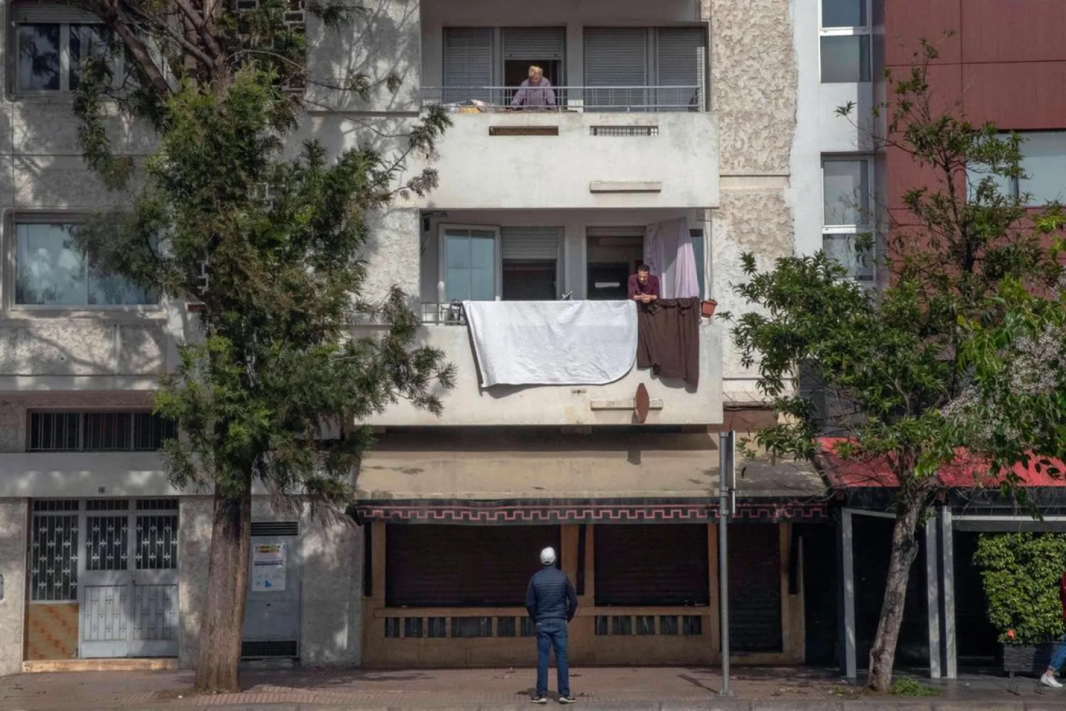 Neighbors have a conversation from their balconies during a health state of emergency and home confinement orders, in Rabat, Morocco. (AP)