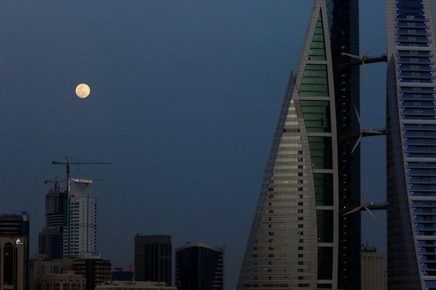 The pink supermoon rises next to Bahrain World Trade Center in Manama, Bahrain, April 7, 2020 (Reuters)