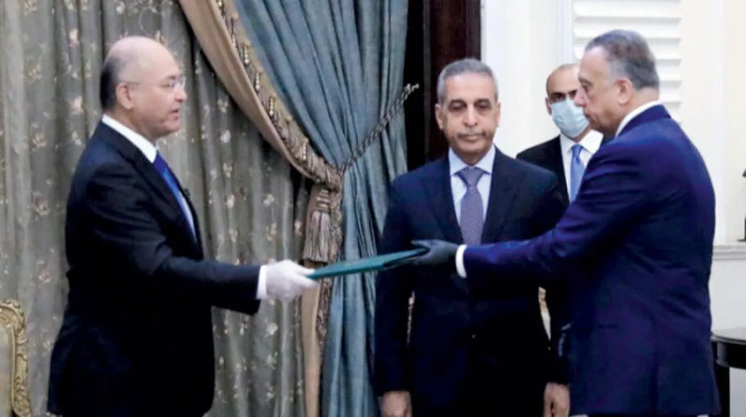 الرئيس العراقي برهم صالح يسلم مصطفى الكاظمي مرسوم تكليفه تشكيل الحكومة أمس (رويترز)