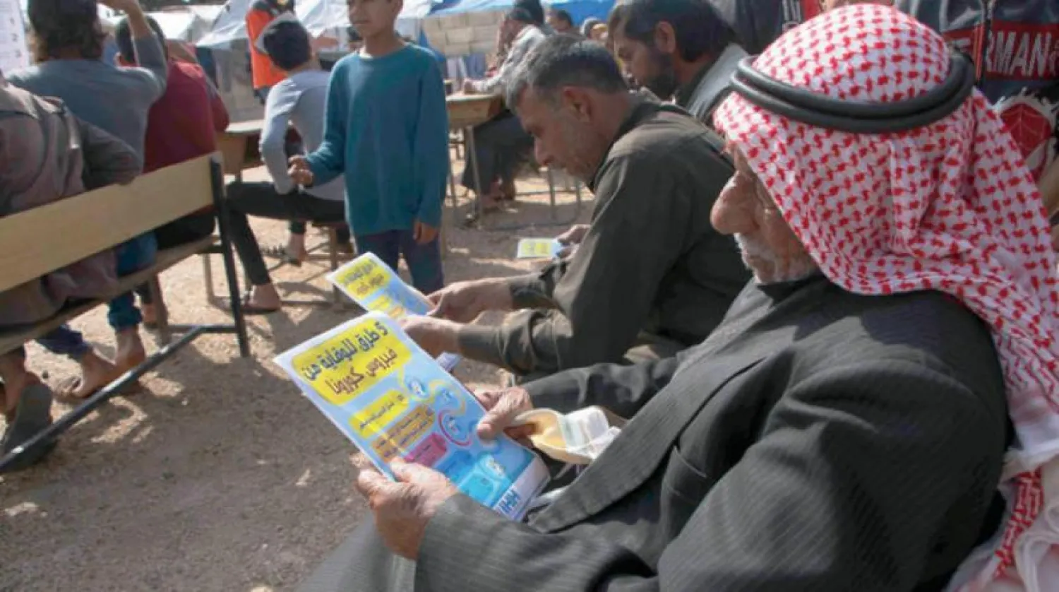 Syrian senior reading safety instructions from a leaflet on the novel virus in northern Syria (AP)