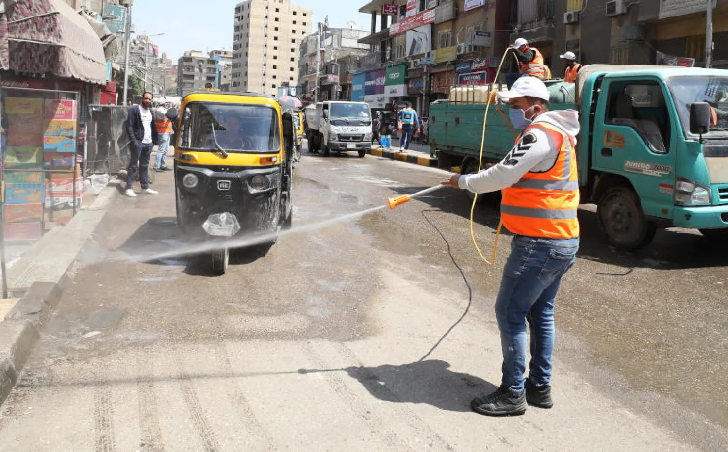 عملية تطهير ضد الفيروسات في أحد شوارع محافظة الجيزة بمصر (إ.ب.أ)