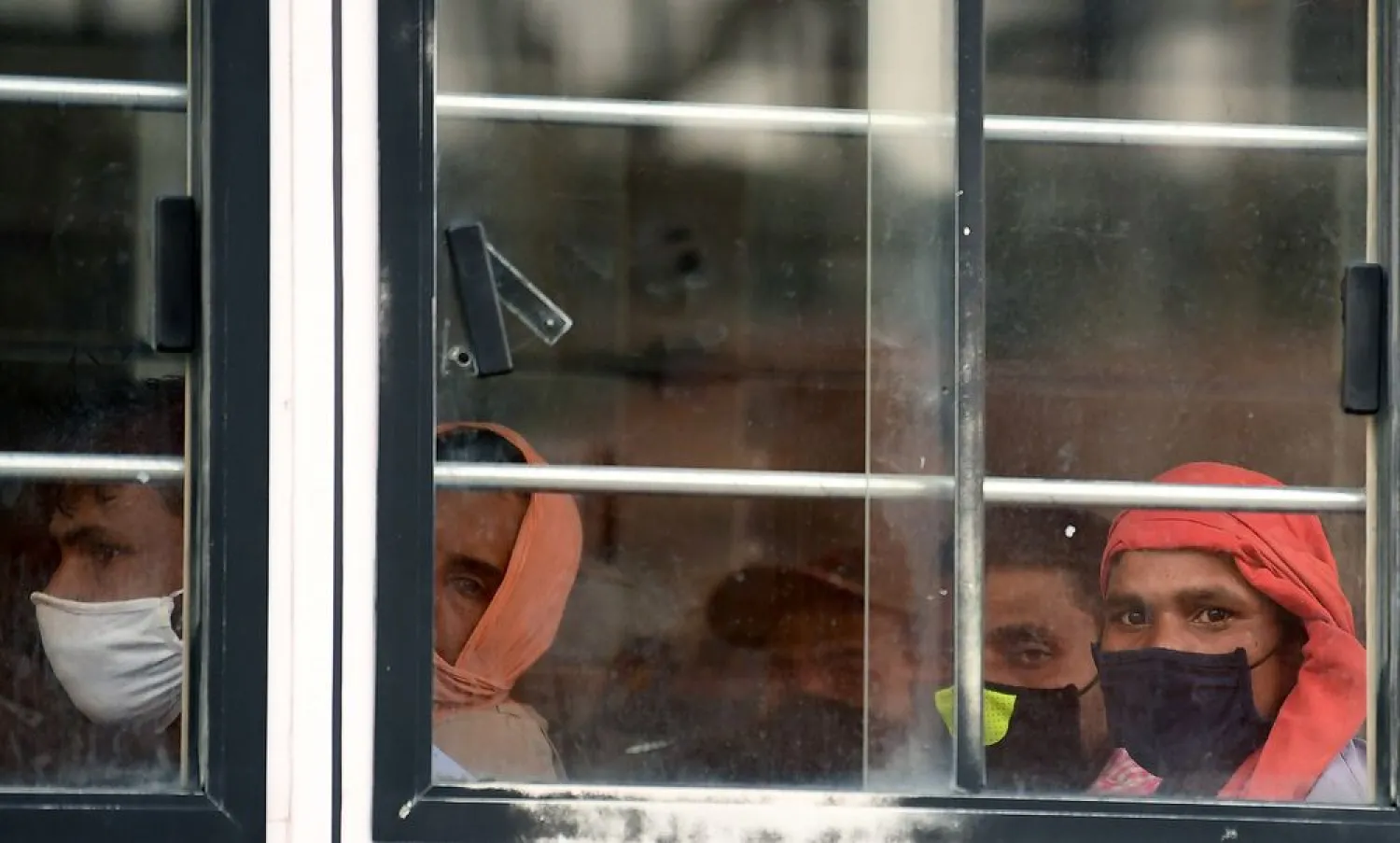 Foreign workers ride a bus transporting them to their workplace in Dubai. Photographer: Karim Sahib/AFP via Getty Images